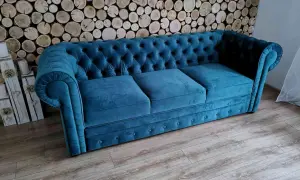 Elegancka kanapa chesterfield w kolorze turkusowym, idealna do salonu. To przykład wysokiej jakości produkcji mebli tapicerowanych.