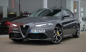 Szary Alfa Romeo Giulia Q4 z żółtymi zaciskami hamulcowymi i felgami z polerowanego aluminium.