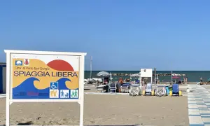 Cartello "Spiaggia Libera" a Porto San Giorgio, con simboli per accessibilità e famiglie.