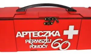 Czerwona, drewniana apteczka z napisem "Apteczka pierwszej pomocy" i białym krzyżem. Idealny prezent dla 60-latki.