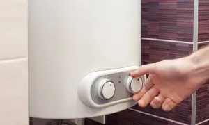 Dłoń reguluje temperaturę na bojlerze elektrycznym 40l energooszczędnym.