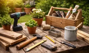 Verktyg och material för ett **diy projekt** ligger utspridda på ett träbord i trädgården. En skruvdragare, hammare, såg, spik och träbitar är redo för skapande.