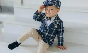 Uroczy chłopiec w eleganckim, kratowanym garniturze i kaszkietem, gotowy na mayoral chrzest.