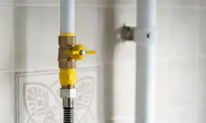 Zawór gazowy z żółtą rączką, gotowy do ponownego podłączenia gazu w mieszkaniu.