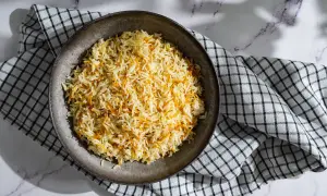 Un plat de riz libanais, parsemé de vermicelles dorés, servi sur une serviette à carreaux.