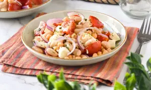 Ensalada de legumbres fresca con garbanzos, judías blancas, tomate y cebolla morada.