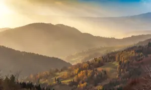 Jesienne słońce rozświetla malownicze wzgórza Beskidu Sądeckiego. Złote liście drzew i mgła tworzą magiczny krajobraz, idealny na odkrywanie beskid sądecki atrakcje.