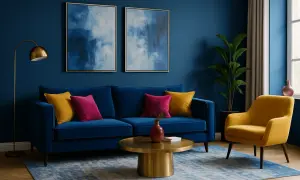 Ein tiefblaues Sofa mit gelben und pinken Kissen. Ein gelber Sessel und ein goldener Couchtisch. Welche Farbe passt zu dunkelblau? Gelb und Pink!