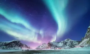 Spektakuläres Nordlicht tanzt über schneebedeckte Berge. Ein magisches Polarlicht-Erlebnis in der arktischen Nacht.
