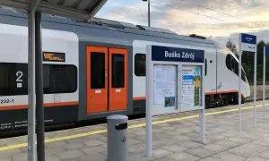 Pociąg do Buska Zdroju na peronie. Tablica informacyjna z nazwą stacji i rozkładem jazdy. Jak dojechać pociągiem do Buska Zdroju? Tu znajdziesz odpowiedź.
