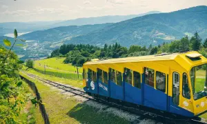 Kolejka linowo-terenowa "Góra Żar" wjeżdża na szczyt, oferując pasażerom malownicze widoki na Beskidy.