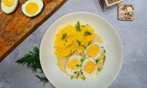 Jajka w sosie musztardowym z puree ziemniaczanym, udekorowane koperkiem i szczypiorkiem. Pyszne danie na obiad.
