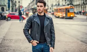 Młody mężczyzna w skórzanej kurtce i jeansach, gotowy na imprezę w stylu lat 90.