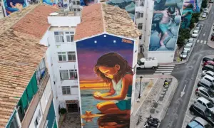 El **Soho Viertel Málaga** se llena de arte con murales gigantes. Una niña mira una estrella en un atardecer mágico.
