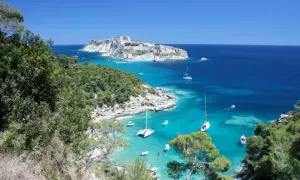 Vista mozzafiato di San Nicola di Tremiti, con il castello in lontananza e barche a vela nelle acque cristalline. Perfetto per scoprire le cose da fare a San Nicola di Tremiti.
