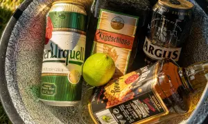 Puszki piwa i butelka whiskey w misce. Zastanawiasz się, ile chmielu do piwa?