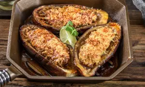 Berenjena airfryer rellena y gratinada, servida en una sartén de hierro fundido con un toque de lima.