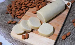 Frisch zubereitetes Marzipan, bereit zum **Marzipan selber machen**. Mandeln und Marzipanrolle auf Holzbrett.