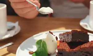 Słodki deser z brownie i lodami, serwowany w pomelo bistro. Idealny na popołudniową kawę.