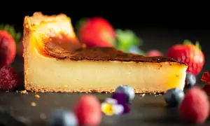 Tranche de flan pâtissier onctueux, avec une croûte dorée et des fruits rouges frais. Un délice pour les yeux et les papilles.