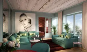 Ett lyxigt vardagsrum i art deco-stil med en stor bild av Greta Garbo, smaragdgröna soffor och ett mönstrat tak. En elegant inredning som andas **art deco Stockholm**.