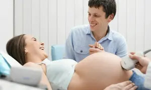Szczęśliwi rodzice podczas badania USG. Lekarz sprawdza tętno płodu, czy nie występuje tachykardia u płodu.