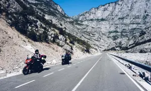 Motocykliści jadący krętą drogą przez skaliste góry w Albanii.