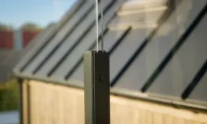 Detalj av ett modernt vindskydd med glas och svart stolpe. Kanske en del av ett projekt för att bygga vindskydd på en altan.
