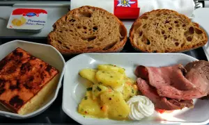Posiłek w samolocie: pieczywo, pieczeń, ziemniaki w sosie i masło. Smak kuchni szwajcarskiej na wysokości.