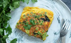 Une omelette aux petits pois et brocolis, garnie de persil frais. Une recette simple et savoureuse pour un repas léger.