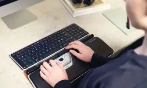 Mains sur un clavier et une souris ergonomique, des pointeurs de souris pour un confort optimal.