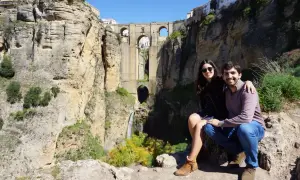 Pareja sonriente posa ante el Puente Nuevo de Ronda, una maravilla para visitar en Ronda en 1 día.