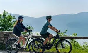 Zwei Personen genießen e bike touren mit Blick auf einen See und Berge.