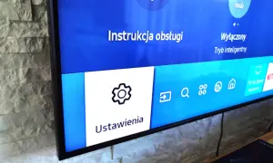 Ekran telewizora Samsung z menu Ustawienia i ikoną koła zębatego.