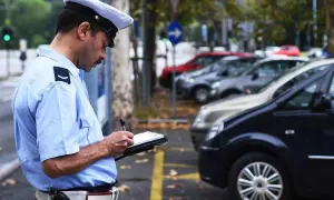 Agente di polizia scrive una multa. Cosa succede se non pago una multa? Potrebbe comportare sanzioni aggiuntive e problemi legali.