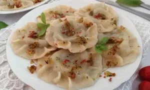 Pyszne pierogi ze szpinakiem, posypane skwarkami i ziołami. Idealne z sosem czosnkowym lub kwaśną śmietaną.