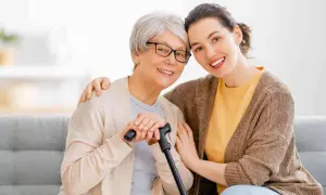 Un modello ap70: due donne sorridono, una anziana con bastone e occhiali, l'altra più giovane con un abbraccio.