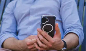 Mężczyzna trzyma telefon, który może wysyłać sygnały haptyczne.