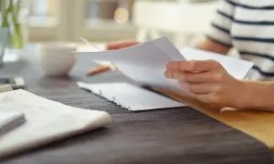 Osoba przegląda dokumenty, przygotowując wniosek o nadanie klauzuli wykonalności.