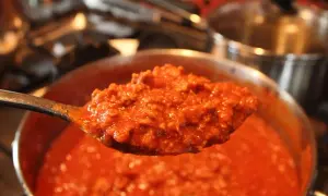 Un cucchiaio di sugo per pasta maritati, denso e saporito, pronto per condire un piatto di pasta fumante.