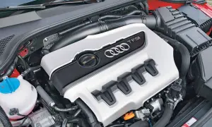 Silnik 2.0 TFSI Audi z charakterystycznymi czterema pierścieniami i osłoną.