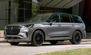 Szary Lincoln Aviator z czarnymi felgami stoi przed nowoczesnym budynkiem.
