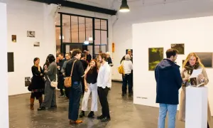 Besucher auf einer **Foto Messe Hamburg** diskutieren Kunstwerke in einer hellen Galerie.