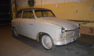 En rostig lloyden bil står i ett garage.