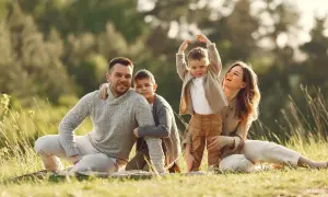 Szczęśliwa rodzina na pikniku. Radosne dzieci i rodzice, symbolizujący siłę więzi, jak w terapii systemowej rodzin.