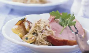 Herzhaftes Fleisch zu bayrisch Kraut mit Bratkartoffeln, garniert mit Petersilie. Ein Klassiker der bayerischen Küche.
