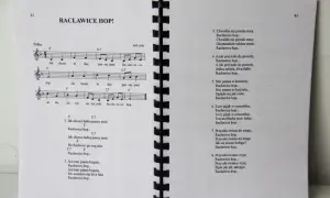 Śpiewnik z piosenkami biesiadnymi, w tym "Racławice hop!". Nuty i teksty do wspólnego śpiewania.