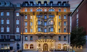 Elegancki hotel w Londynie z oświetloną fasadą i wejściem.