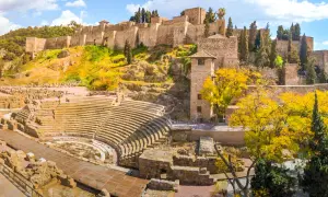Vestiges d'un théâtre romain et de l'Alcazaba, un site historique à visiter à Malaga, sous un ciel bleu éclatant.