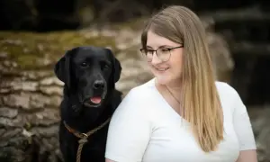 Ein schwarzer Labrador und eine Frau mit Brille lächeln. Perfekt für eine vorlage trainingsplan hund.